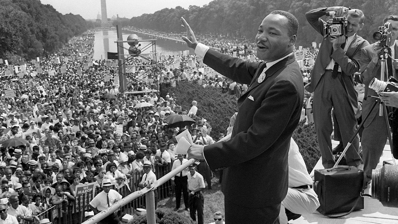 Der US-Bürgerrechtler Martin Luther King winkt bei einer Kundgebung von der Lincoln-Gedächtnisstätte in Washington aus seinen Anhängern zu (im Hintergrund das Washington Monument, Archivfoto vom 28.08.1963).