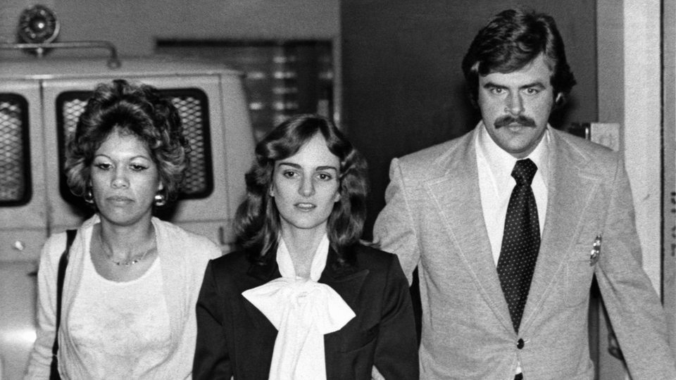 Patricia Hearst wird 1976 von zwei US Marshalls in Handschellen abgeführt.