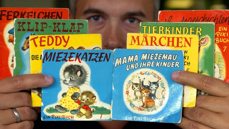 Ein Sammler hält die erste Serie Pixi-Bücher, die im Jahre 1954 erschienen sind, in den Händen.