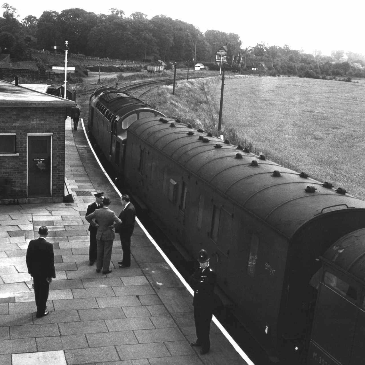 Kripo- und Polizeibeamte stehen am 10. August 1963 auf dem Bahnsteig in Chaddington (Buckinghamshire) neben dem ausgeraubten Zug.
