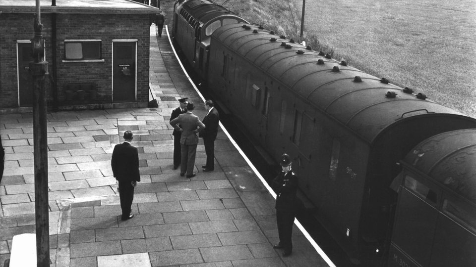 Kripo- und Polizeibeamte stehen am 10. August 1963 auf dem Bahnsteig in Chaddington (Buckinghamshire) neben dem ausgeraubten Zug.