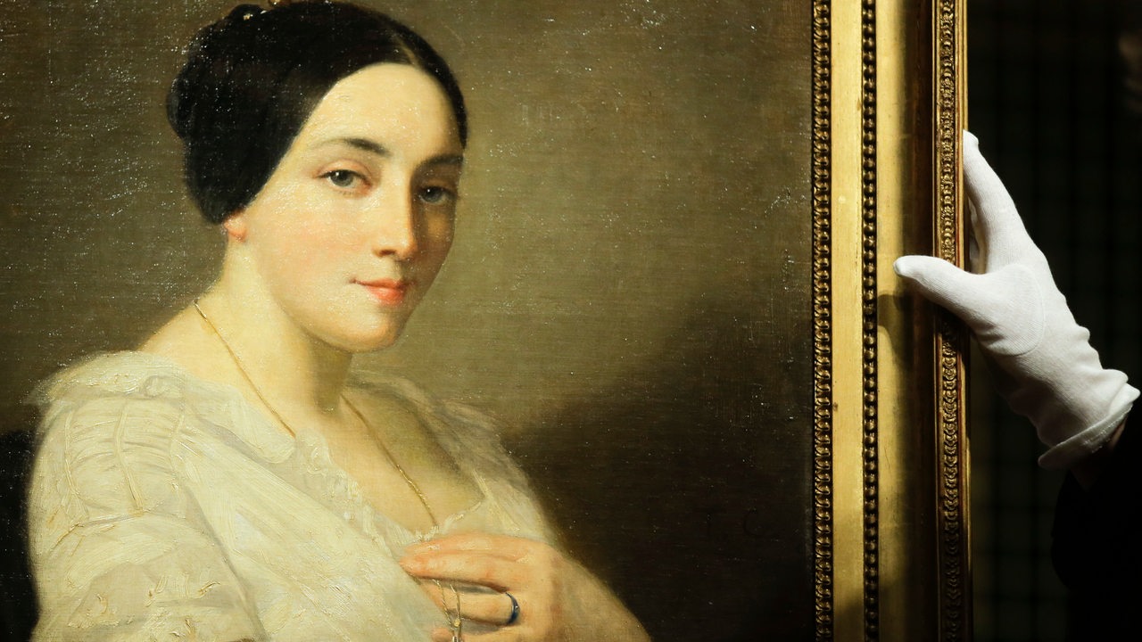 Das Kunstwerk "Porträt einer sitzenden Frau" von Thomas Couture wird hochgehalten. (Sammlung Gurlitt)