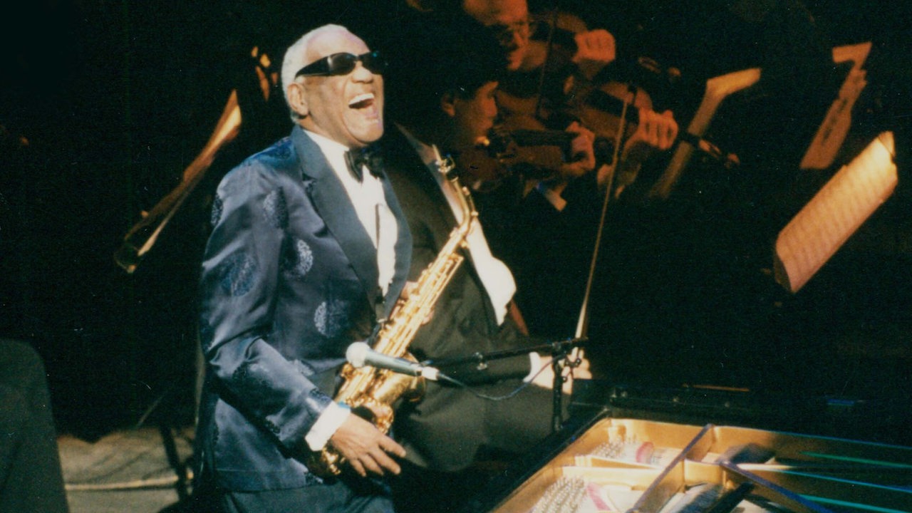 Ray Charles singt mit Saxophon und  Klavier auf der Bühne 1995.