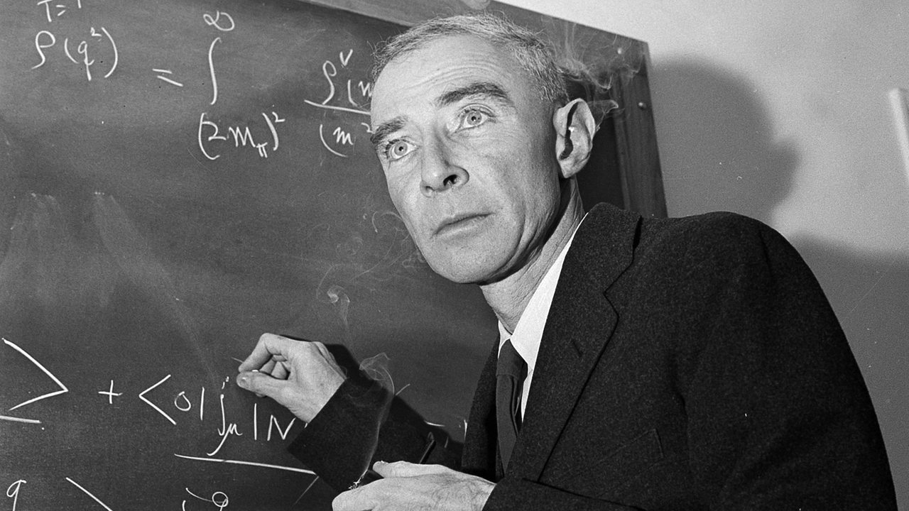 Dr. J. Robert Oppenheimer schreibt eine Formel an die Tafel.