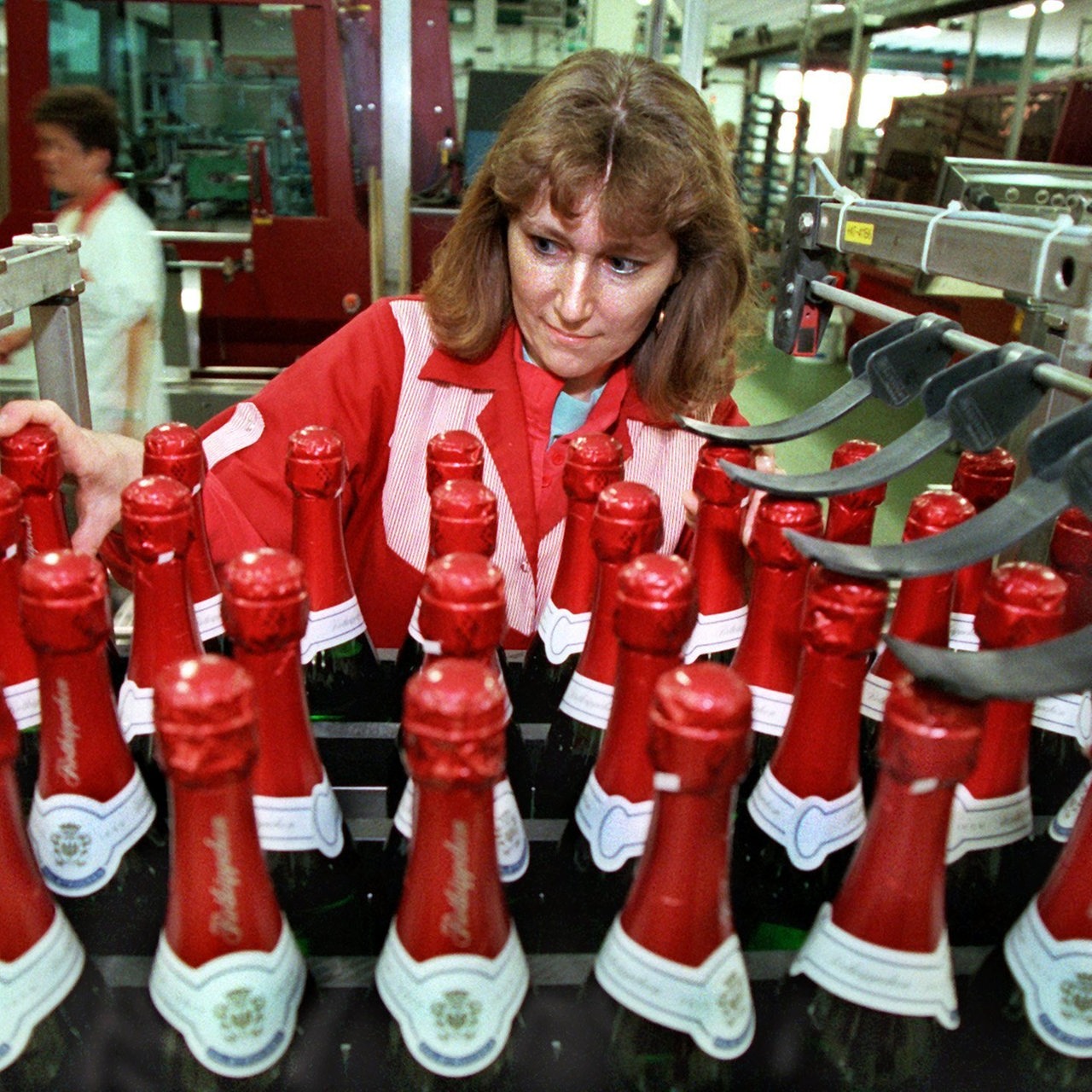 Eine Angestellte prüft in der Rotkäppchen-Sektkellerei Freyburg die Flaschen