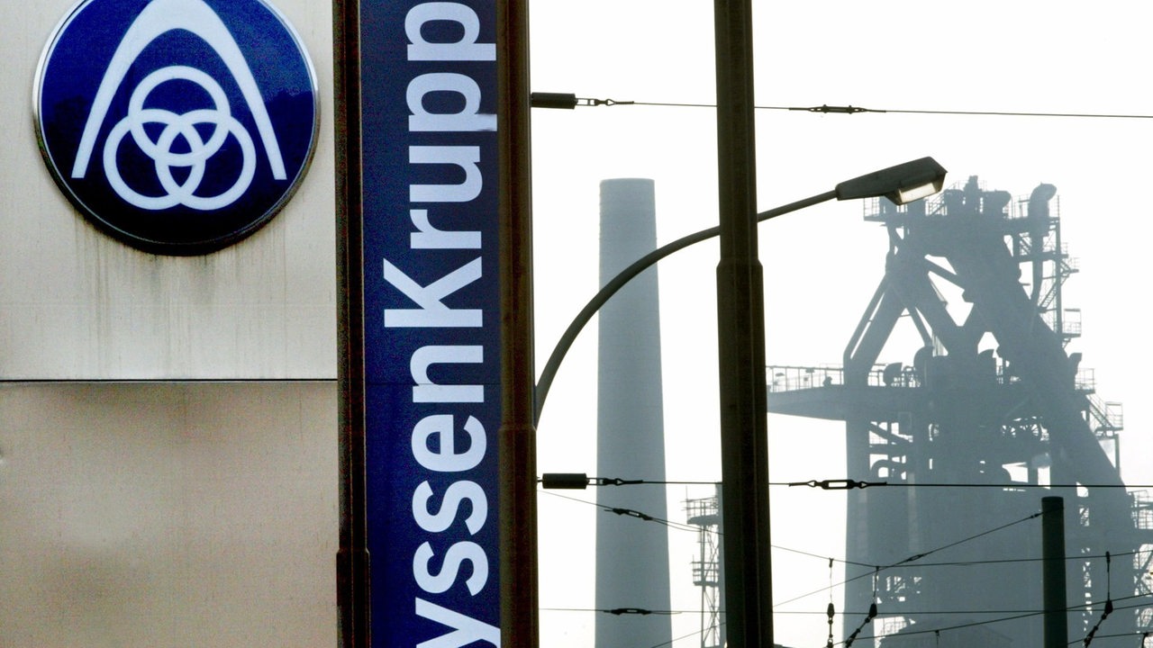 Das Firmenschild der Konzernzentrale des Stahlwerkes der ThyssenKrupp AG in Duisburg-Bruckhausen steht in unmittelbarer Nähe eines Hochofens