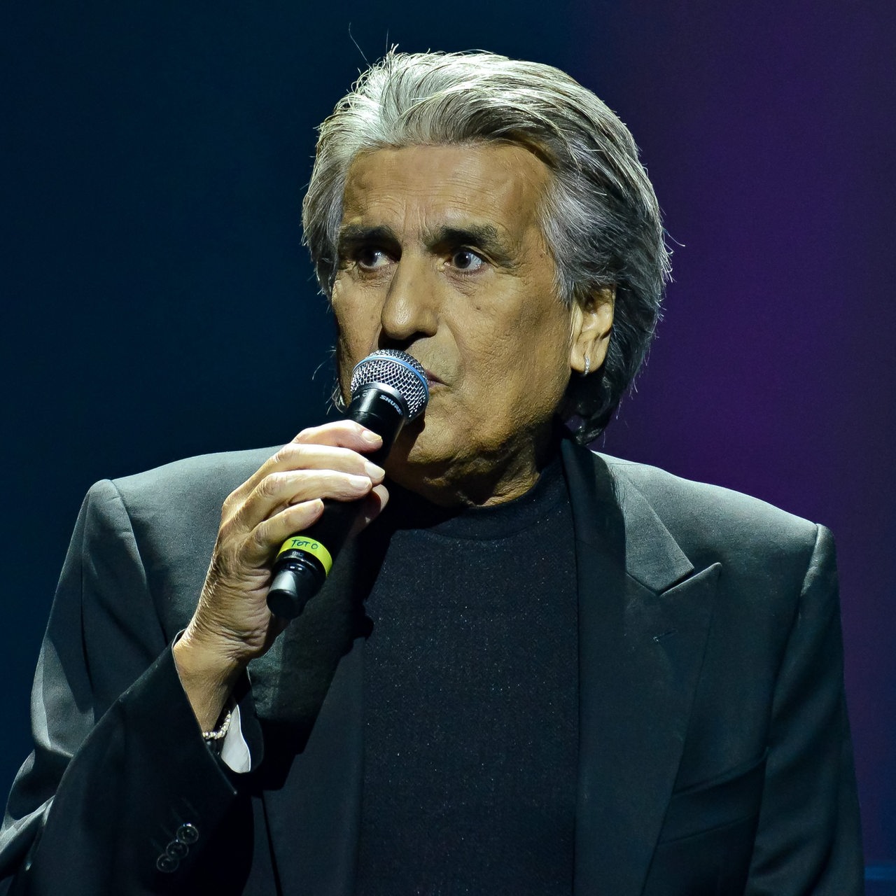 Porträt des italienischen Sängers Toto Cutugno mit Mikrofon auf der Bühne