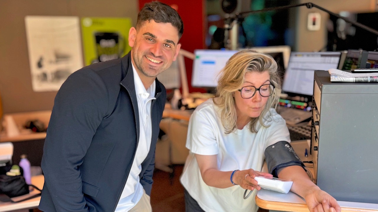 Sportwissenschaftler Mazlum Demirci checkt den Blutdruck von Susan 