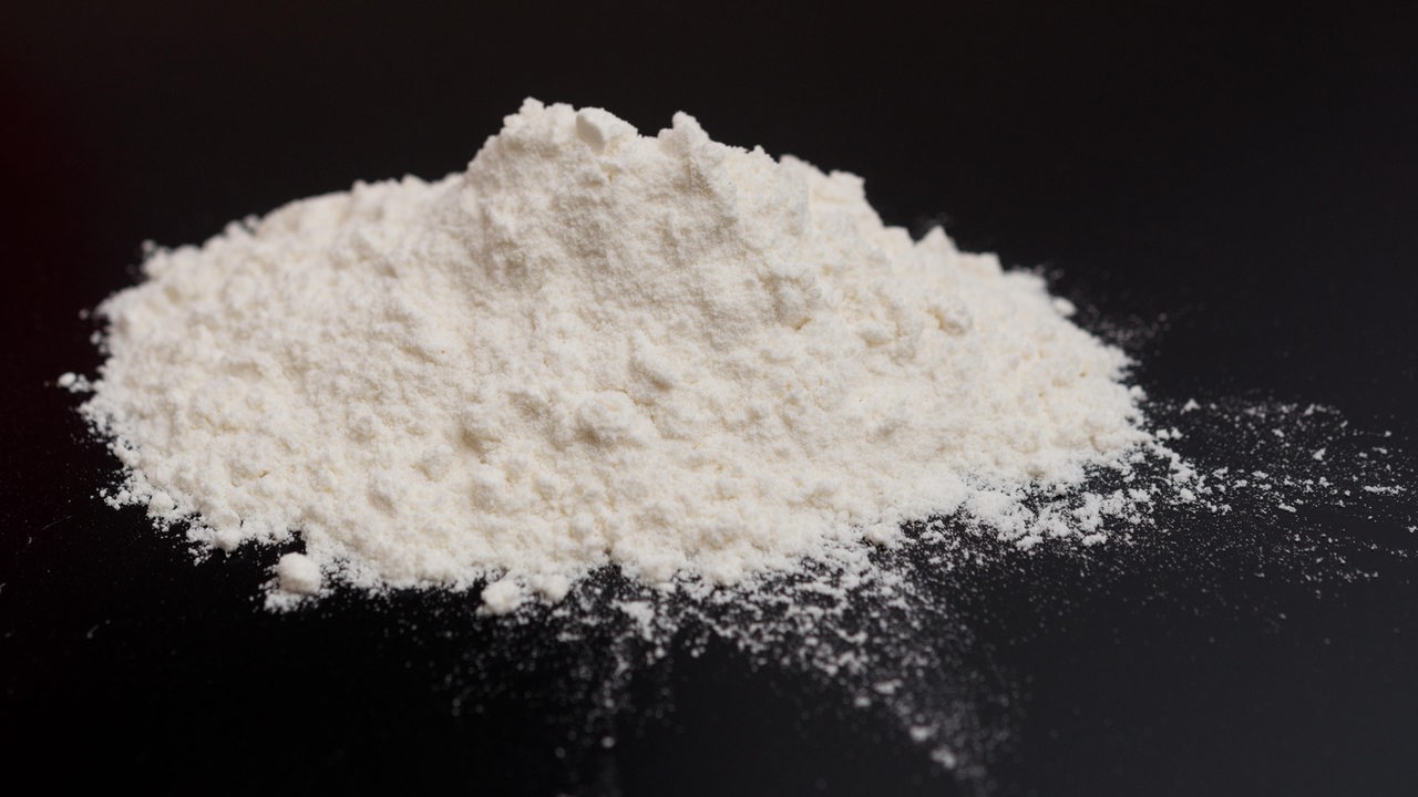 Ein weißer Haufen Kokain auf schwarzem Tisch